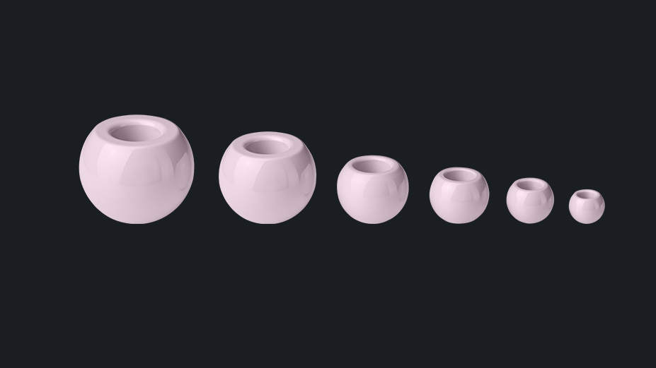 Various ceramic femoral heads in descending sizes, showcased against a dark background, representing advanced solutions in veterinary orthopedics and surgeries.